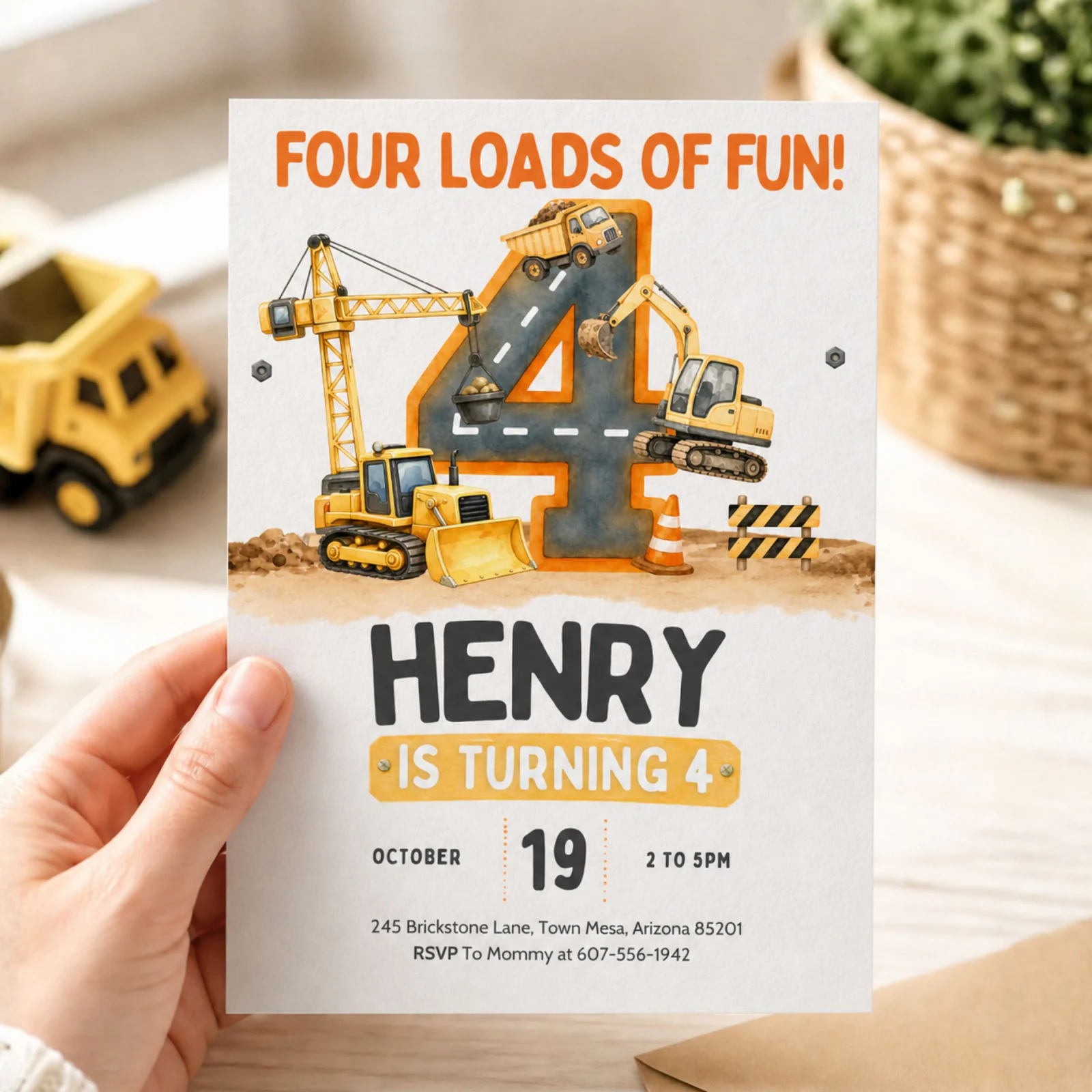 Construction 4th birthday invitation held in hand, featuring a dump truck, excavator, and crane. Editable Canva template.