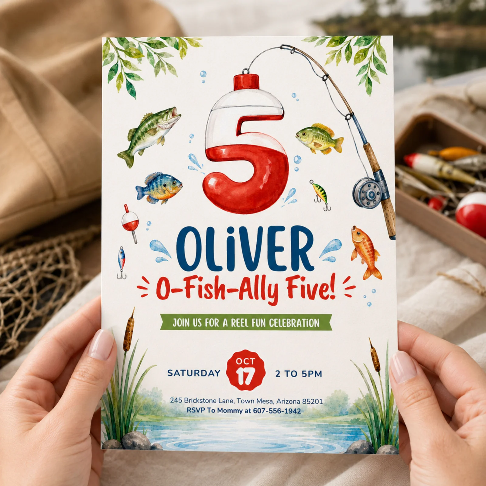 Fishing 5th birthday invitation held in hands, featuring watercolor fish and a bobber number 5.
