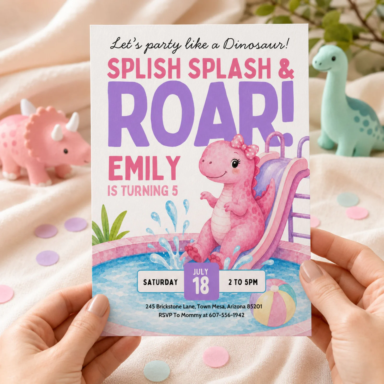 Dinosaur Pool Party Invitation held in hands, featuring a pink T-rex on a water slide in a pool.