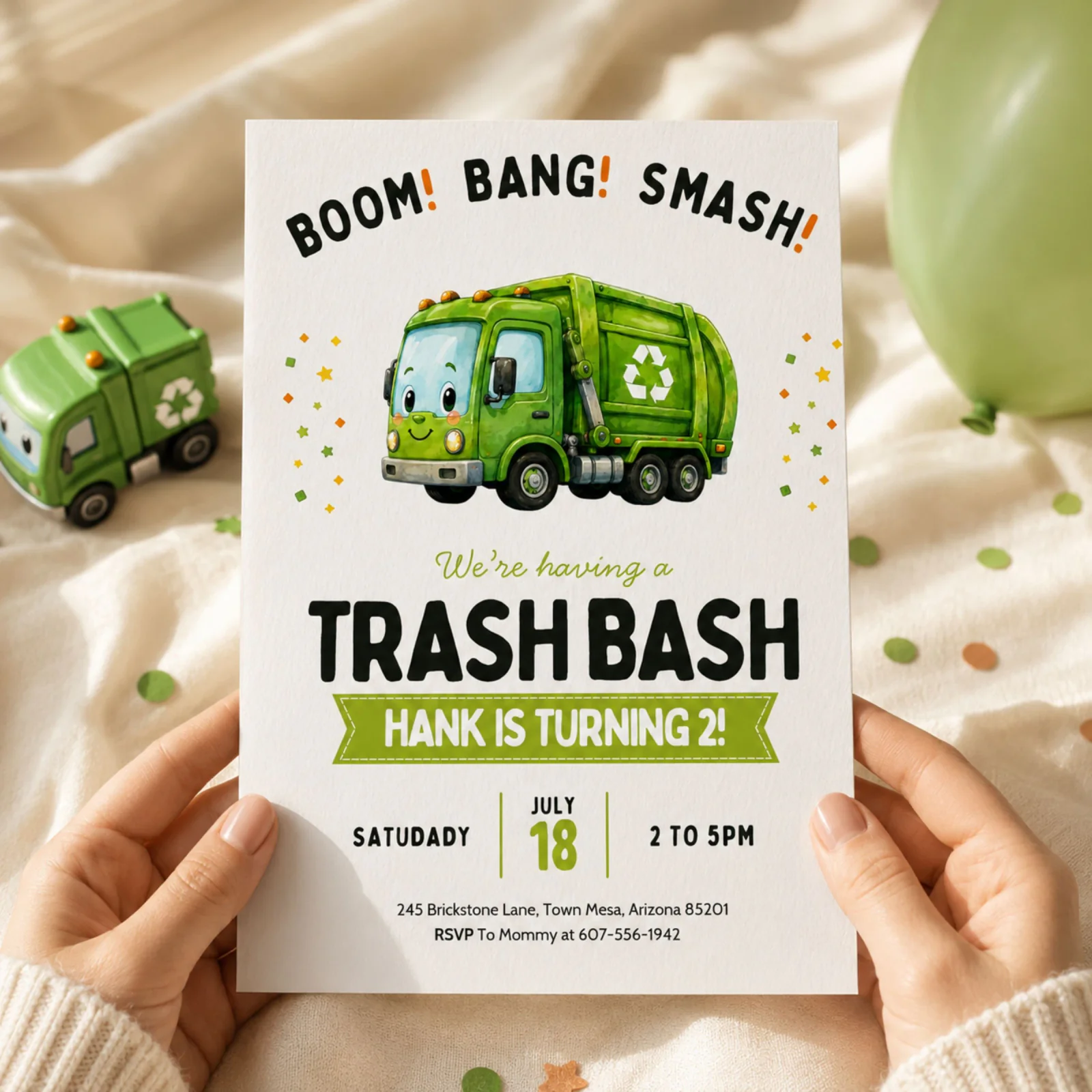 Trash Bash Birthday Invitation card held in hands, featuring a happy green garbage truck design.