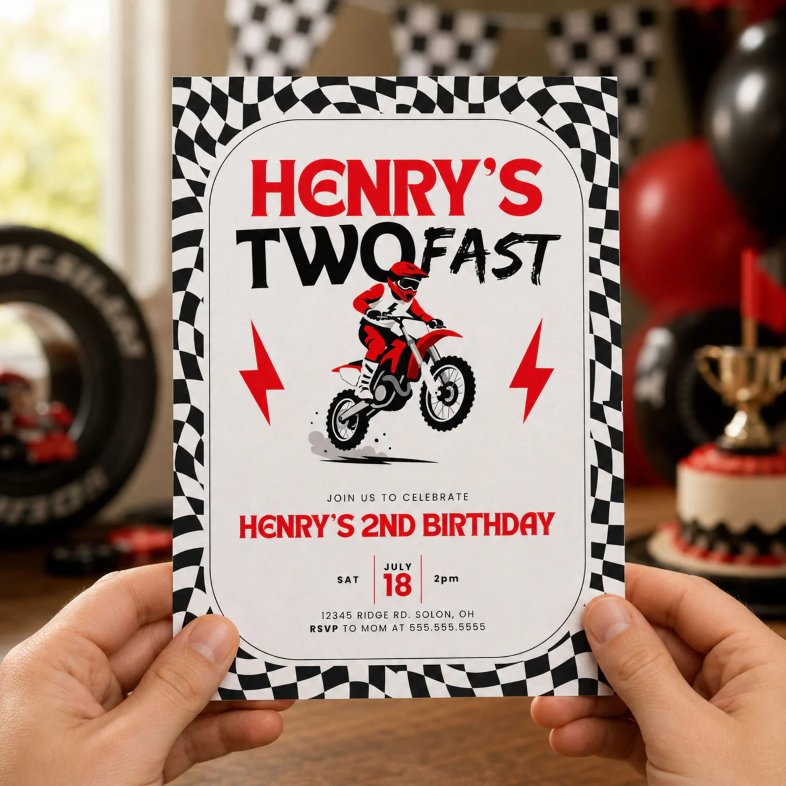 Two Fast dirt bike birthday invitation held in hands, featuring a motocross theme and checkered border.